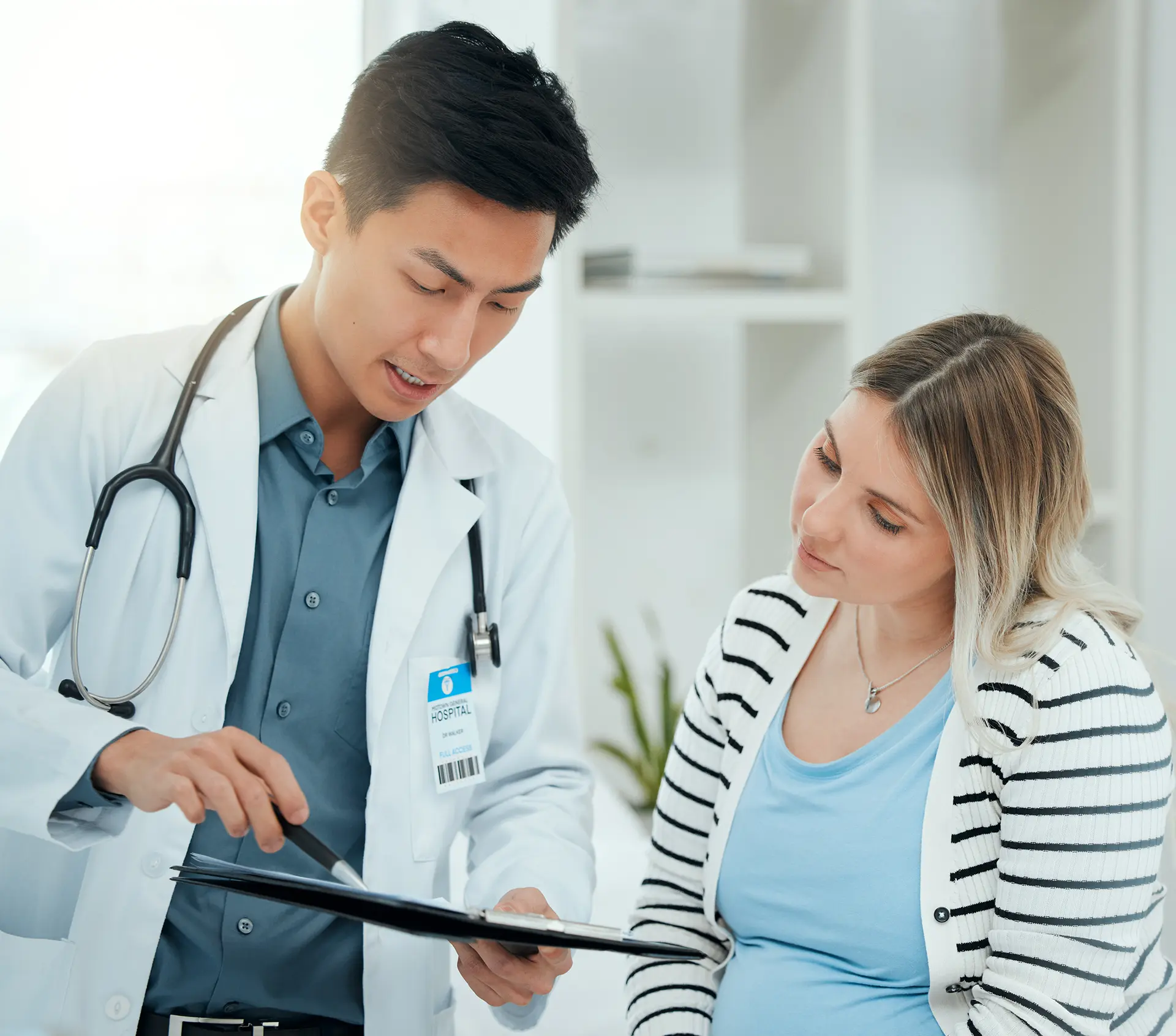 Hospital, pregnancy and doctor with woman on tablet for consulting, wellness and prenatal appointment