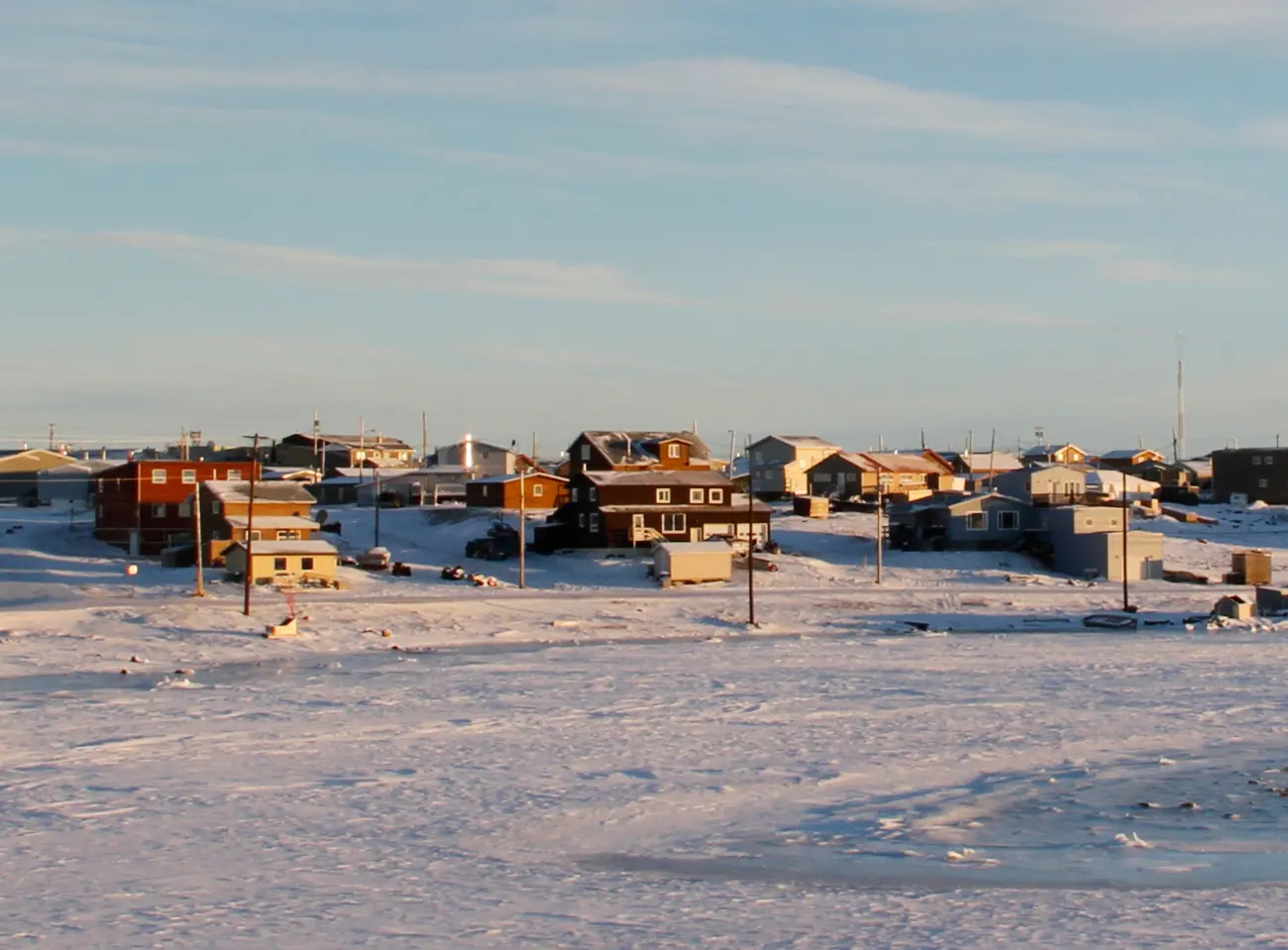 Arctic community of Cambridge Bay in the fall with snow on the ground and blue skies